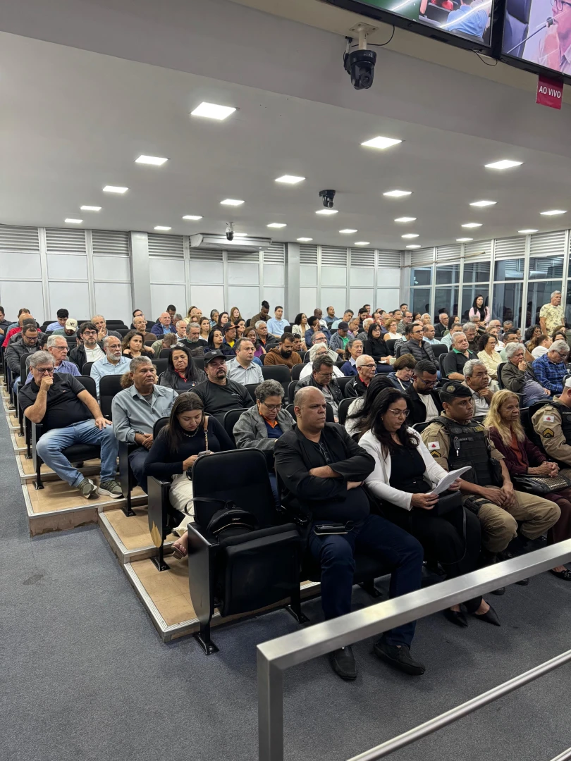 Mesa de reunião com representantes e comunidade durante audiência pública