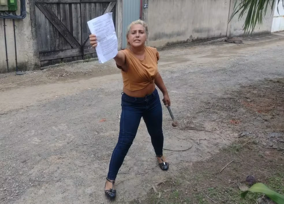 Ana Paula Fernandes é vista com um martelo em mãos, enquanto seu ex-marido a acusa de ter ido à sua casa no estado do Rio de Janeiro para ameaçá-lo em 2023.