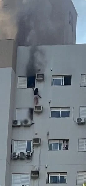 Uma mulher se pendura em um suporte de ar-condicionado durante incêndio em prédio no Paraná, tentando salvar a mãe e uma criança.