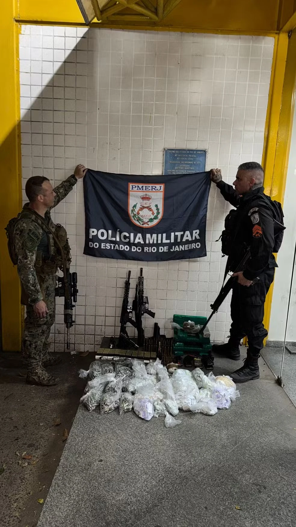 Material apreendido durante operação com a Polícia Militar: armas e drogas exibidas no local em ação na Cidade de Deus, Rio de Janeiro.