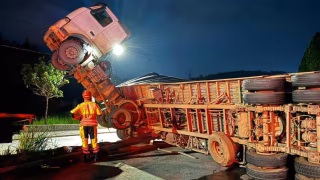 Carreta tomba e motorista fica preso a cinco metros de altura em MG