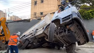 Durante conserto de buraco, caminhão da Sabesp cai em nova cratera