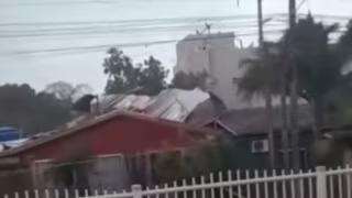 Vento de mais de 100 km/h arranca telhado de prédio e o lança sobre casa em Santa Catarina; vídeo mostra momento