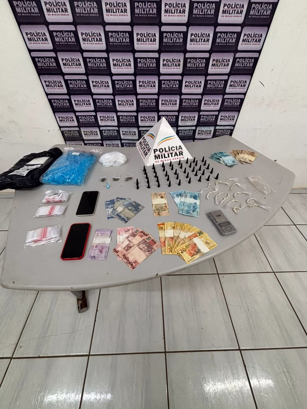 Durante a busca pessoal e ao inspecionar um embrulho descartado no chão, os militares descobriram porções de maconha, cocaína, crack e dinheiro em espécie