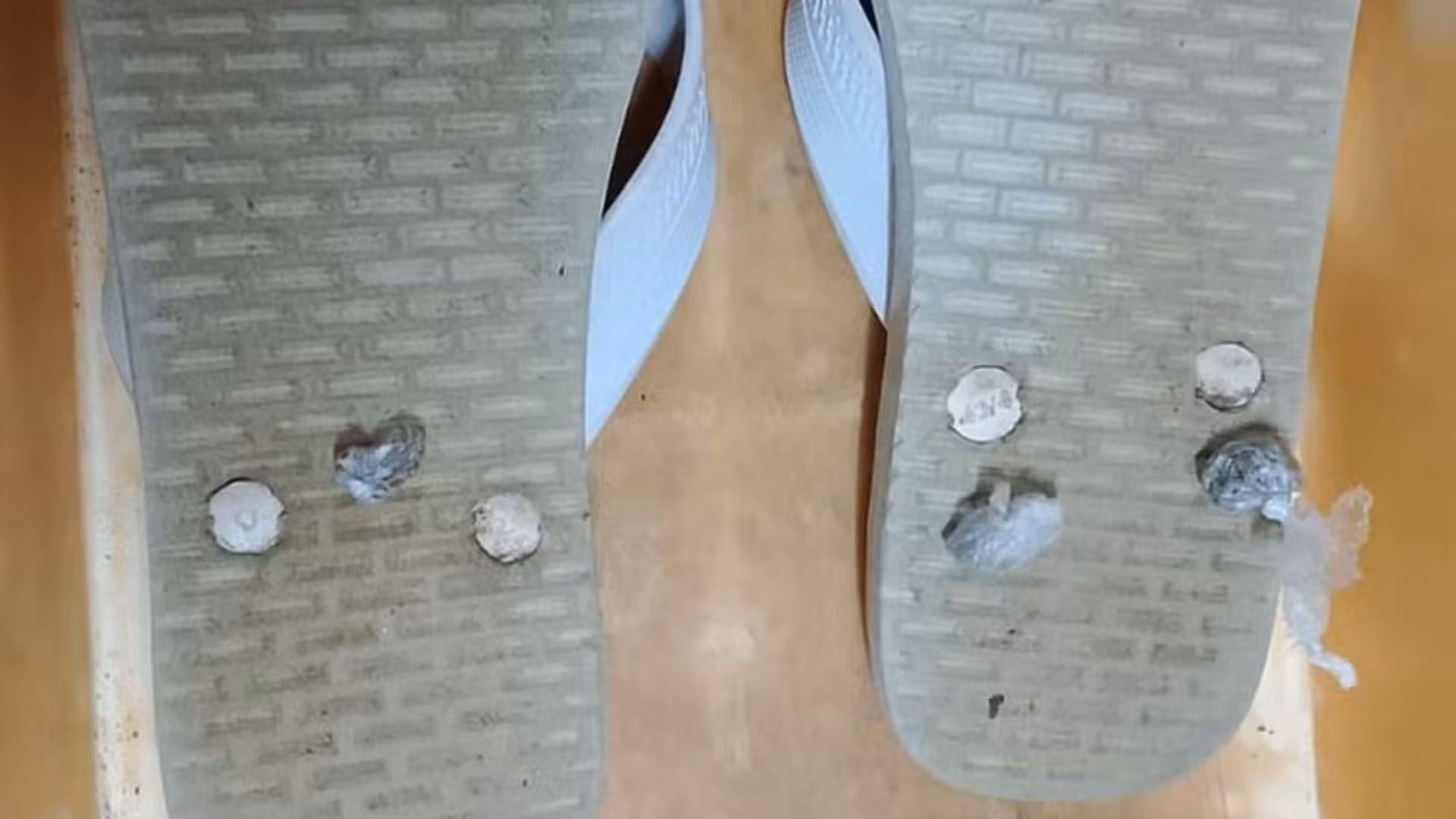 Durante a inspeção, os policiais encontraram as porções da droga escondidas nas solas dos chinelos