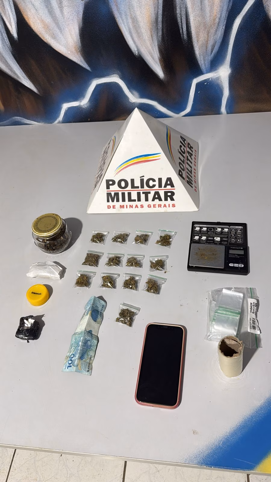 Quando percebeu a aproximação das viaturas, o suspeito tentou fugir para o interior do prédio, mas acabou contido e abordado. Com ele, os policiais encontraram entorpecentes, dinheiro e uma bolsa com forte odor de maconha.