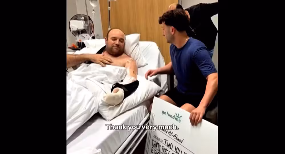 Herói de atentado na Austrália recebendo cheque de dinheiro doado em vaquinha e agradecendo