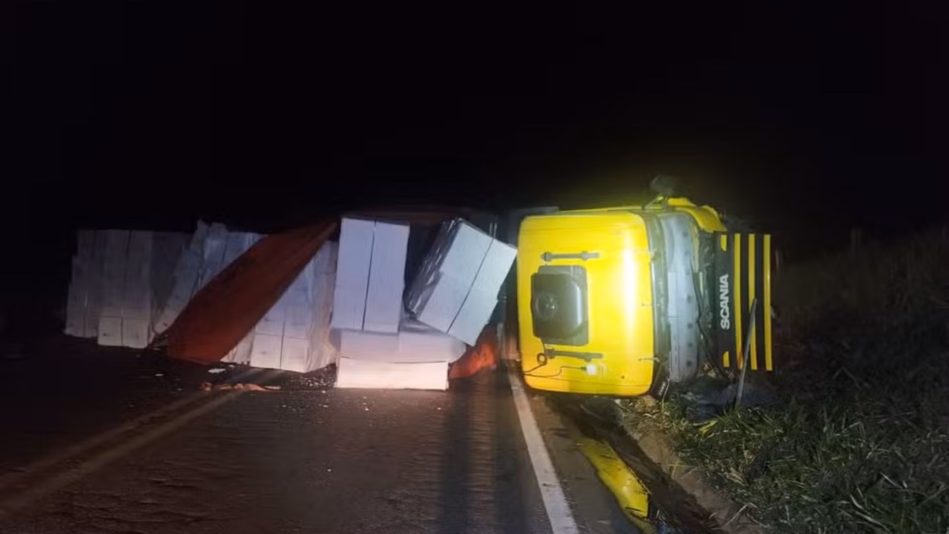 Com a sequência de impactos, o caminhão tombou e ficou atravessado na pista.