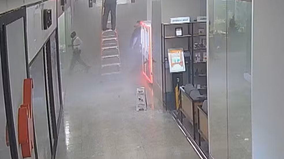 Anderson, já sem paletó, entra pela última vez na loja. Esta é a última imagem dele antes de ser retirado desacordado