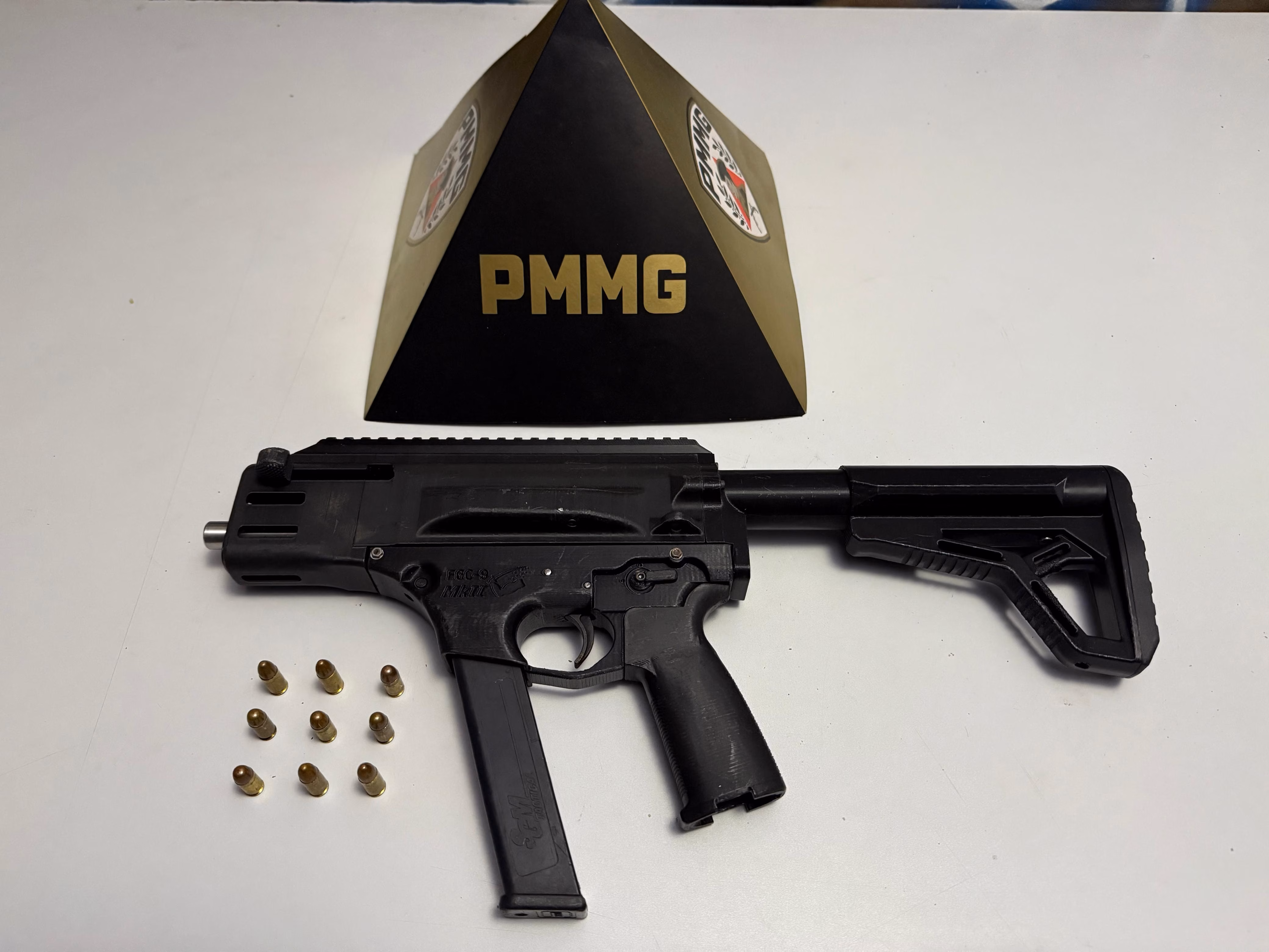 . Os policiais realizaram uma varredura no quintal e, dentro de uma caixa d’água utilizada como depósito de lixo, localizaram uma mochila com o armamento e as munições.