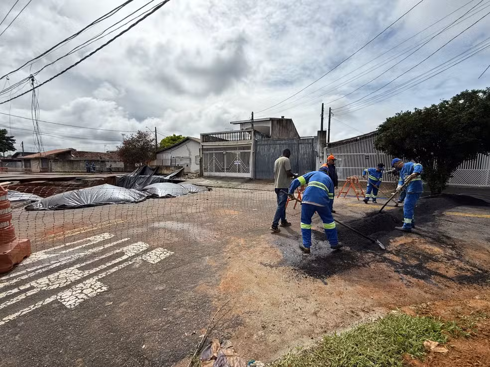 Após cratera aumentar, prefeitura faz barreira de asfalto para evitar avanço da água.