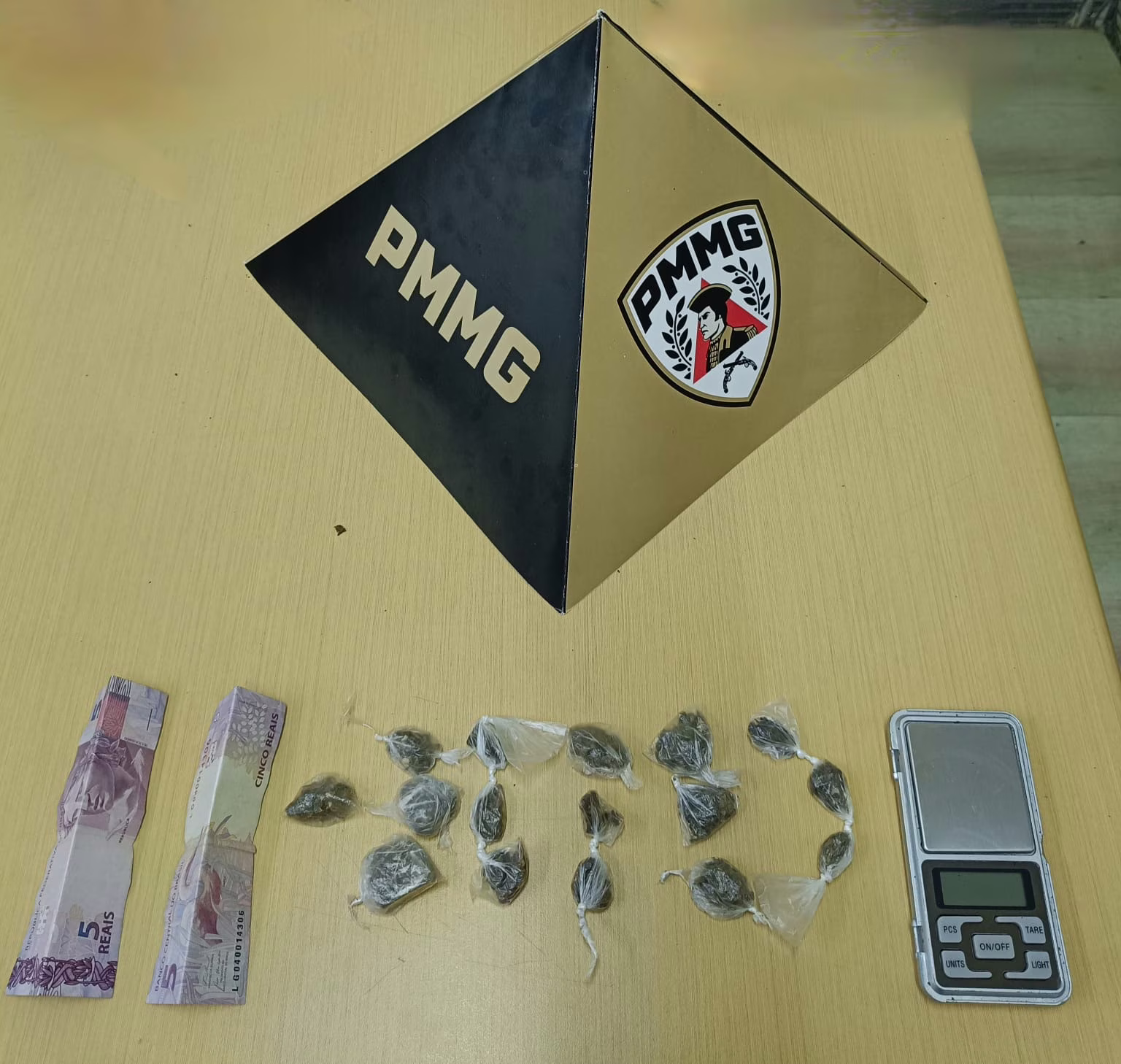 Um deles, ao perceber a aproximação da viatura, levantou-se abruptamente e entrou em um beco próximo, carregando uma pequena bolsa preta.