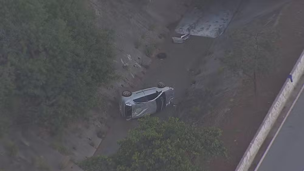Carro capota e cai em córrego na Avenida Jacu-Pêssego, em Itaquera, Zona Leste de São Paulo.