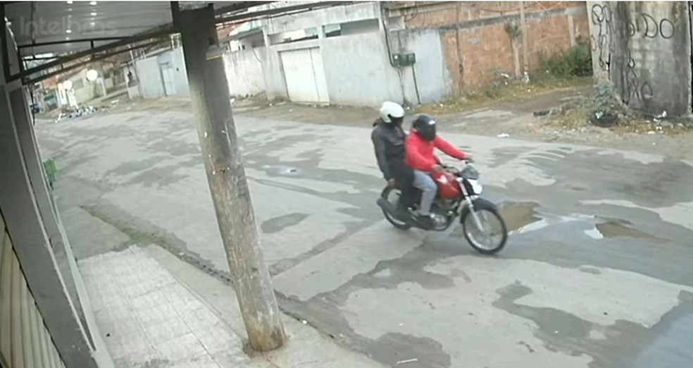 Milicianos circulam de moto após o assassinato de um padeiro em 2025