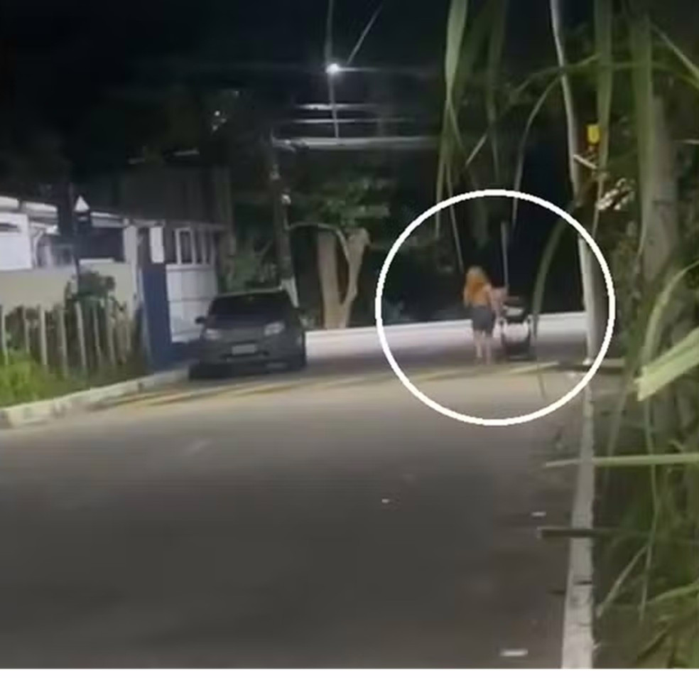 Mulher conduzindo carrinho de bebê pela rua