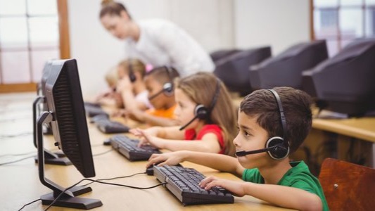 criança mexendo em computador na escola