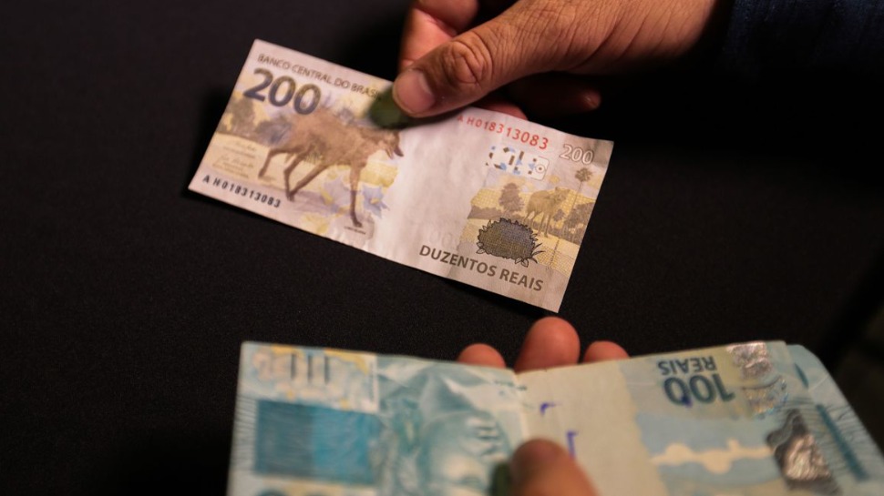 pessoa com notas de dinheiro na mão
