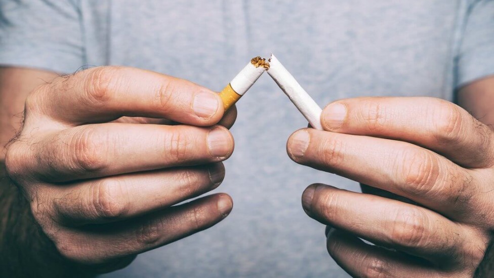 homem quebrando cigarro